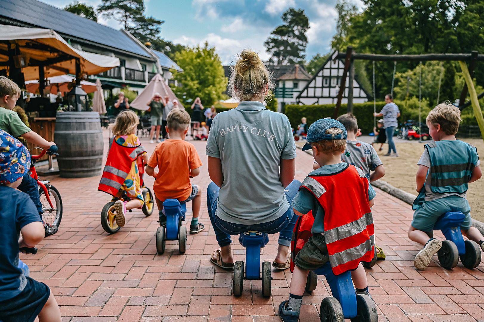 Kinderbetreuerin macht mit Kindern ein Rennen auf dem Laufrad