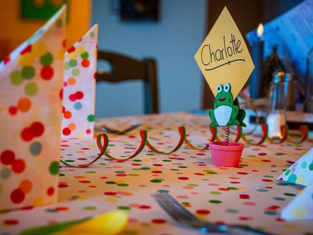 Nahaufnahme des bunt dekorierten Esstisches im Restaurant mit Namensschild