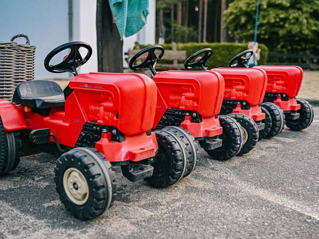 Rote Kindertraktoren parken in einer Reihe 
