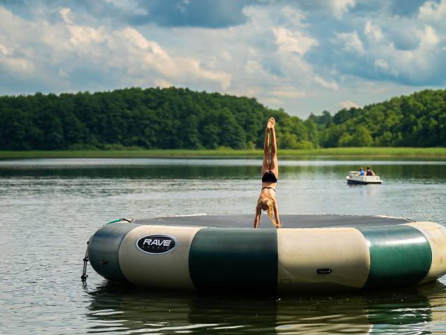 mädchen macht einen Handstand auf einem Wassertrampolin am großen Labussee