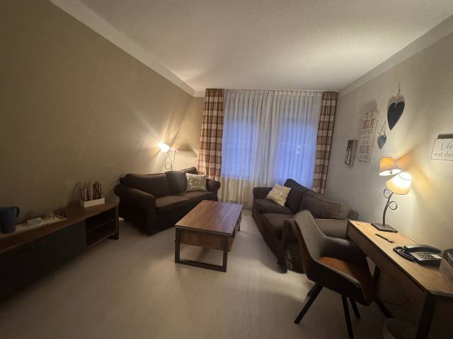 Wohnraum mit Sofas, Sideboard Tisch und Stuhl