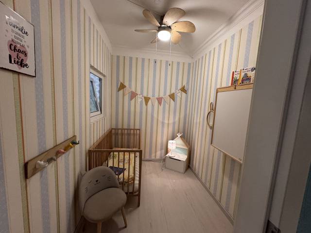 Babyzimmer mit Gitterbett, Wickelkommode und kleinem Kästchen