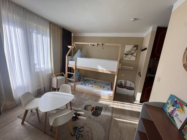 Kinderzimmer mit Doppelbett, Tisch und schönem Teppich