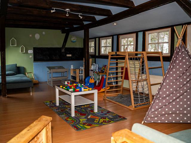 Spielzimmer für Kinder mit Tipi, Klettergerüst, Lego, Tafel und Couch