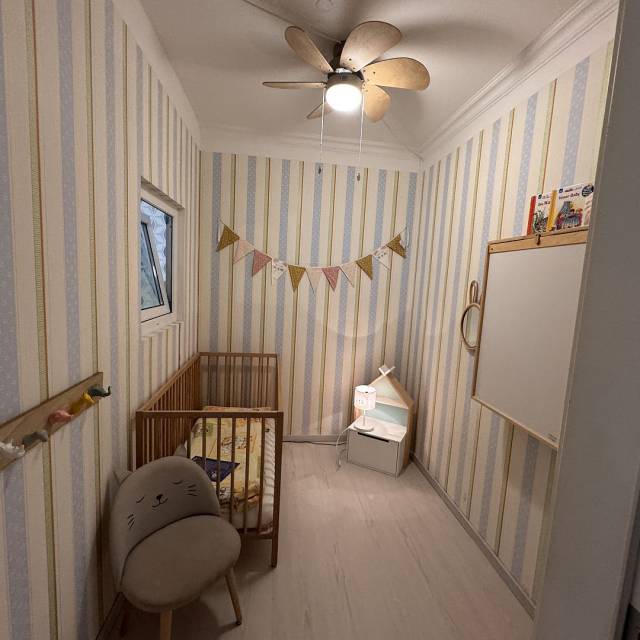 Babyzimmer mit Gitterbett, Wickelkommode und kleinem Kästchen