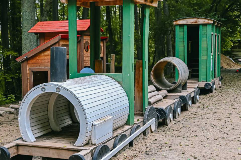 Auf dem Spielplatz steht ein Westernzug mit Waggons gebaut aus Holz