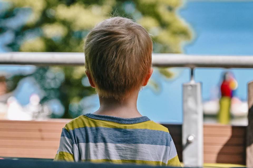 Kleiner Junge blickt auf der Terasse auf den Labussee