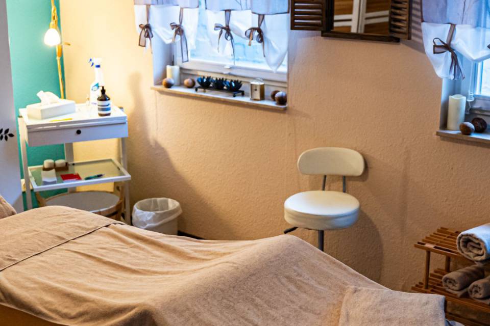 Massageliege mit Massageutensilien im Wellnessraum bei Borchards Rookhus