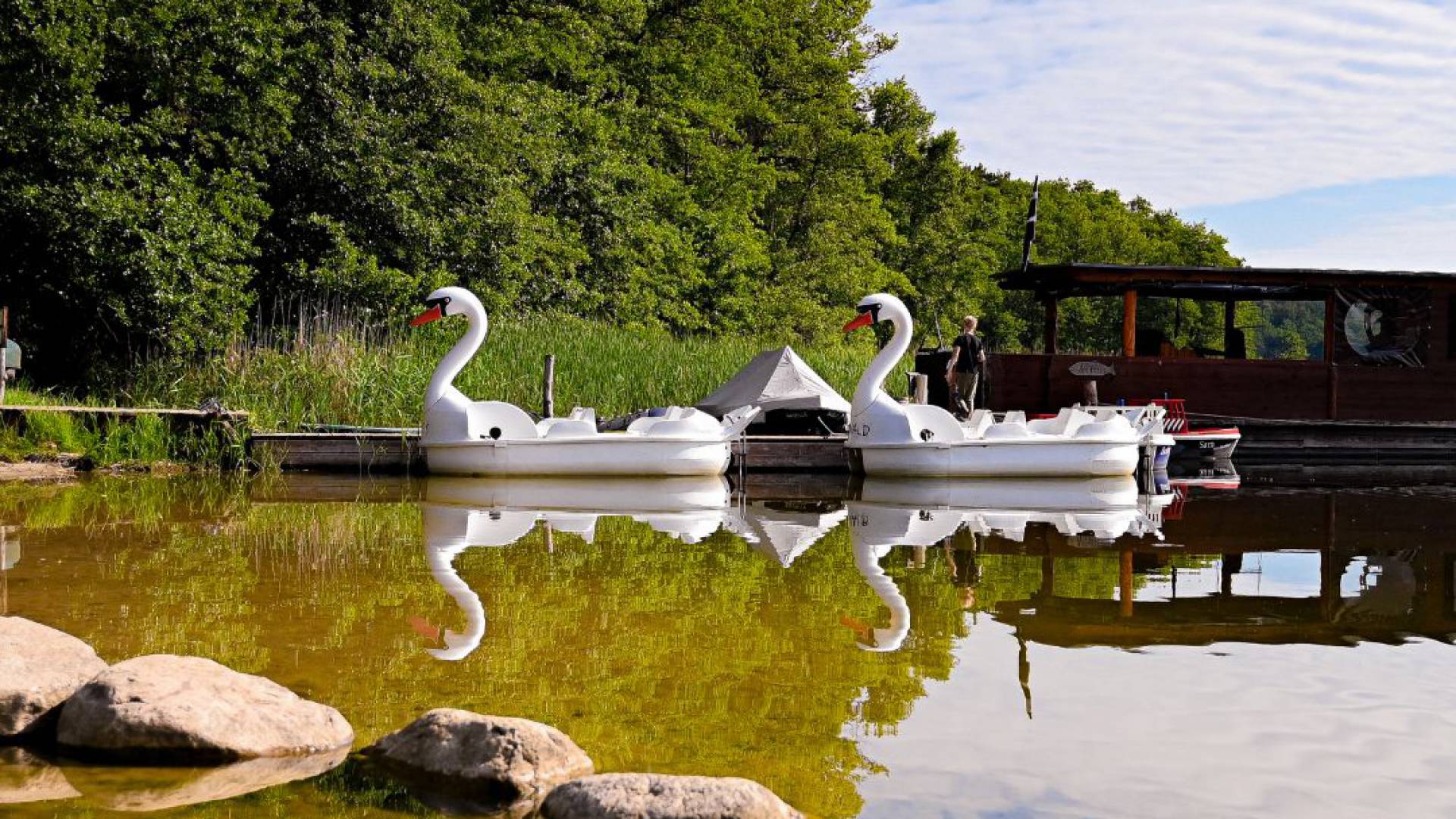 Tretboote in Schwanenform auf dem Labusssee und im Vordergrund ein Steinhalbkreis