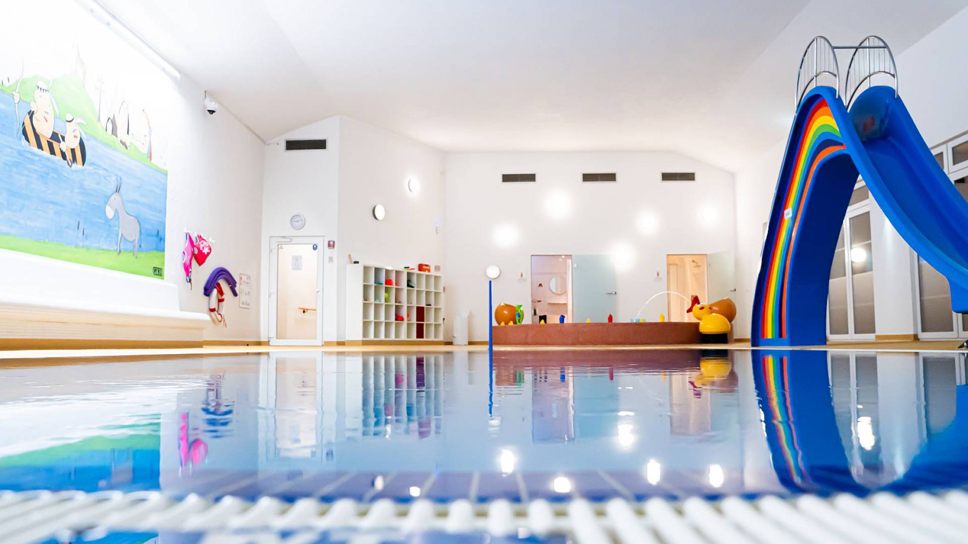Schwimmbad mit Pool, großer bunter Rutsche und Babybereich