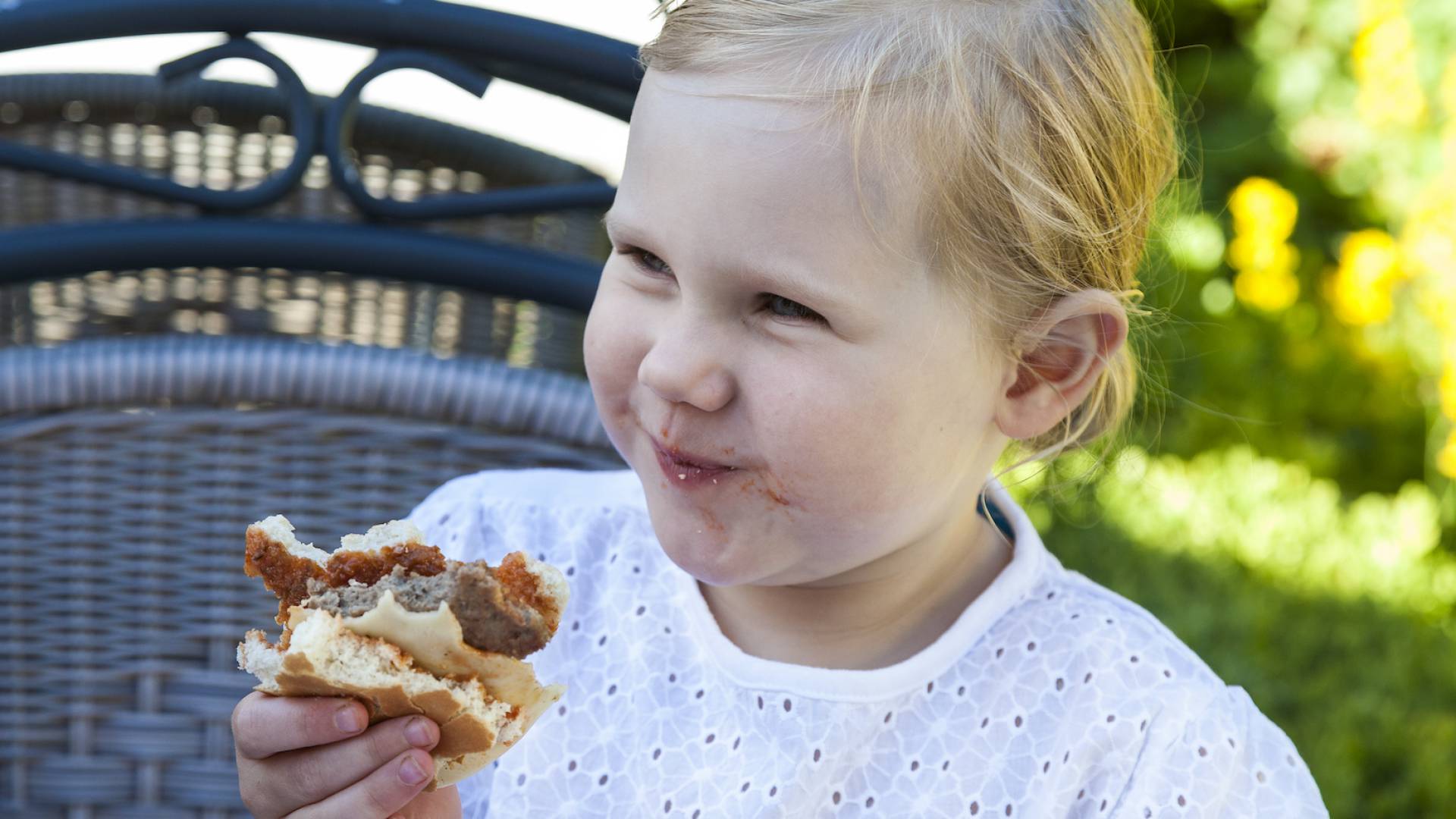 Ein Mädchen beißt genussvoll in einen Burger im Rookhus